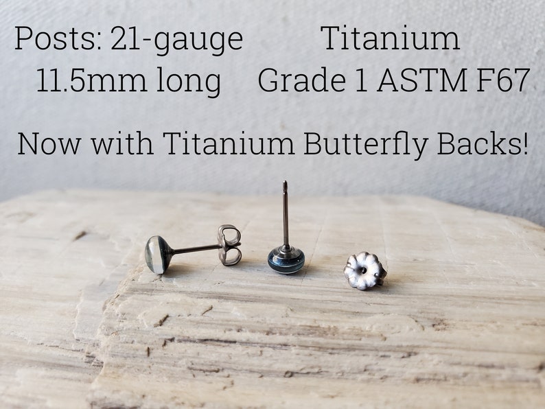 May include: Three titanium earring posts with butterfly backs. The posts are 21 gauge and 11.5mm long. The text "Titanium Grade 1 ASTM F67" and "Now with Titanium Butterfly Backs!" is visible in the image.