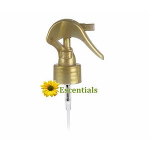 May include: Gold plastic spray bottle top with a clear plastic tube. The bottle top has a gold trigger and a gold cap.