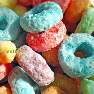 Può includere: Primo piano di cereali colorati, tra cui pezzi a forma di anello blu, rossi e arancioni e pezzi oblunghi. L'immagine ha un'estetica luminosa e allegra, con un focus sulla varietà di colori e trame.