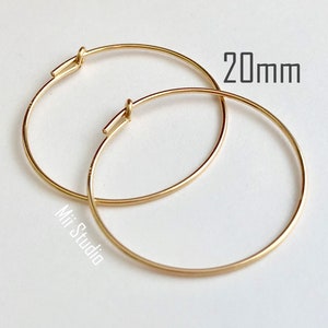 Pode incluir: Um par de brincos de argola de ouro, com 20 mm de diâmetro. Os brincos são simples e elegantes, e seriam um ótimo presente.