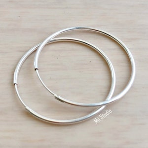 May include: A pair of silver hoop earrings. The hoops are simple and classic, with a smooth finish.