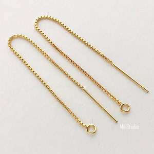 May include: A pair of gold chain earrings with a small loop at the end of each chain. The chains are about 2 inches long.