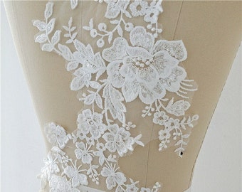 May include: White floral lace applique with sequins. The lace features a large flower with smaller flowers and leaves. The lace is on a white background.