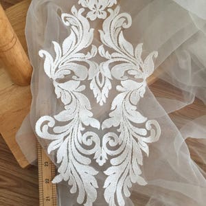Puede incluir: Aplique de encaje blanco con un dise&ntilde;o floral. El aplique mide aproximadamente 23 pulgadas de largo y 8 pulgadas de ancho.