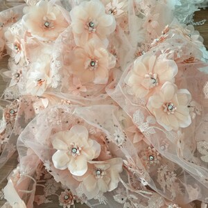 Puede incluir: Tela de encaje floral de color melocot&oacute;n con flores 3D y pedrer&iacute;a. La tela es transparente y delicada, con un tacto suave y rom&aacute;ntico.