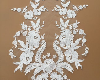 May include: White floral lace applique with delicate flowers and leaves. This lace trim is perfect for adding a touch of elegance to wedding dresses, bridal accessories, or other craft projects.