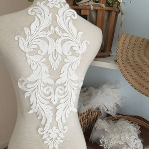 Puede incluir: Aplique de encaje blanco con un dise&ntilde;o floral. El aplique est&aacute; en un maniqu&iacute; blanco y mide aproximadamente 45 cm de alto.