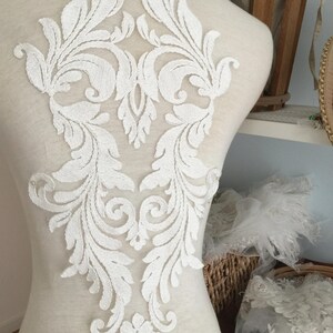 Puede incluir: Aplique de encaje blanco con un dise&ntilde;o floral. El encaje es delicado e intrincado, con una variedad de espirales y hojas. Ser&iacute;a perfecto para agregar un toque de elegancia a un vestido de novia, un vestido de novia o cualquier otra prenda para una ocasi&oacute;n especial.
