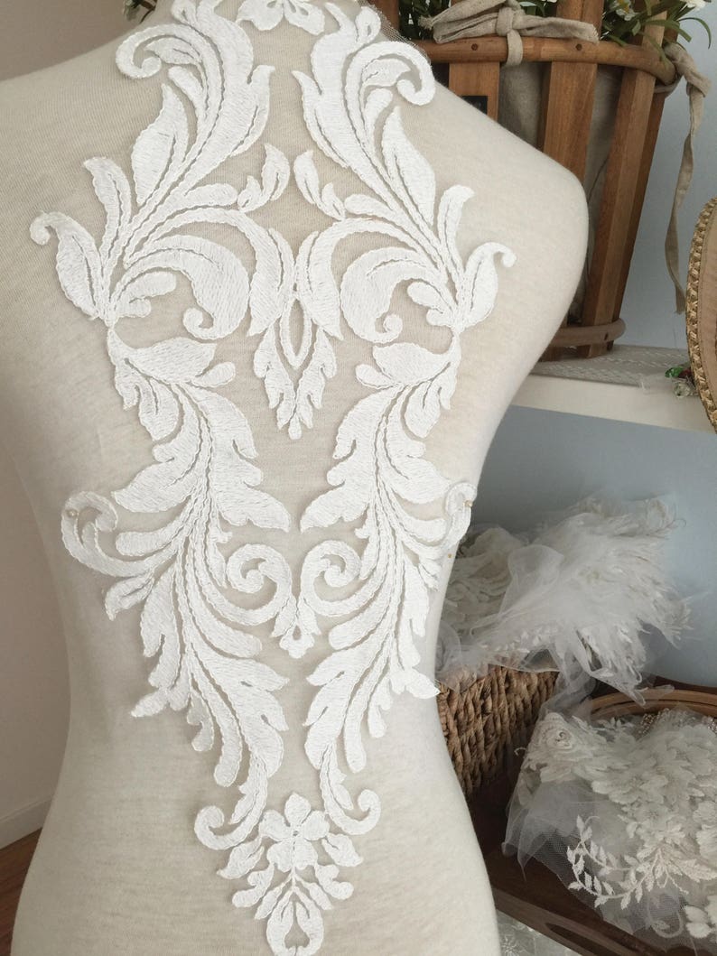 Puede incluir: Aplique de encaje blanco con un dise&ntilde;o floral. El encaje es delicado e intrincado, con una variedad de espirales y hojas. Ser&iacute;a perfecto para agregar un toque de elegancia a un vestido de novia, un vestido de novia o cualquier otra prenda para una ocasi&oacute;n especial.