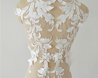 May include: White floral lace applique with a delicate design. The lace is on a sheer mesh backing and is perfect for adding a touch of elegance to any project.