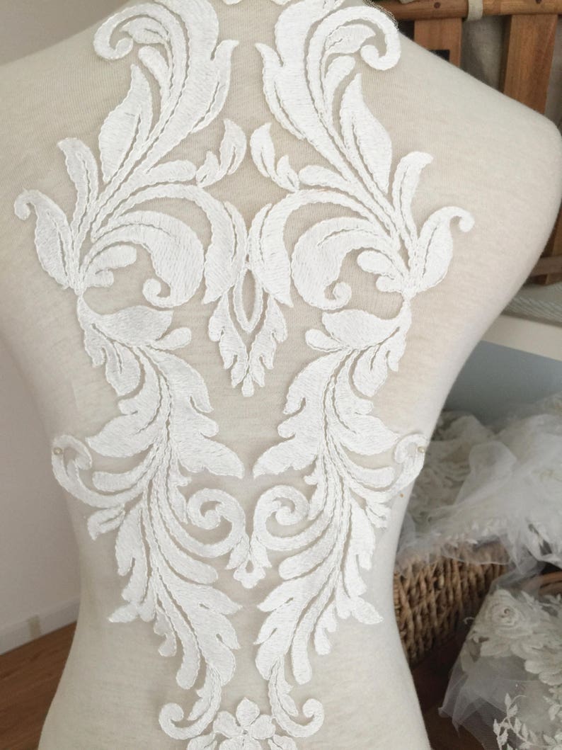 Puede incluir: Aplique de encaje blanco con un dise&ntilde;o floral. El aplique es perfecto para agregar un toque de elegancia a cualquier prenda.