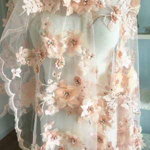 Puede incluir: Tela de encaje floral de color melocot&oacute;n con flores 3D y pedrer&iacute;a. La tela es transparente y delicada, con un borde festoneado.