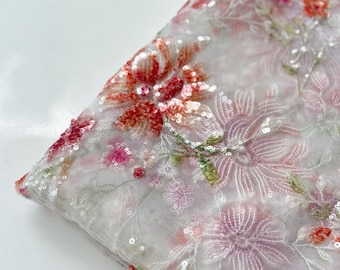 May include: White sheer fabric with a floral pattern embroidered with sequins. The flowers are in shades of pink, red, and green.