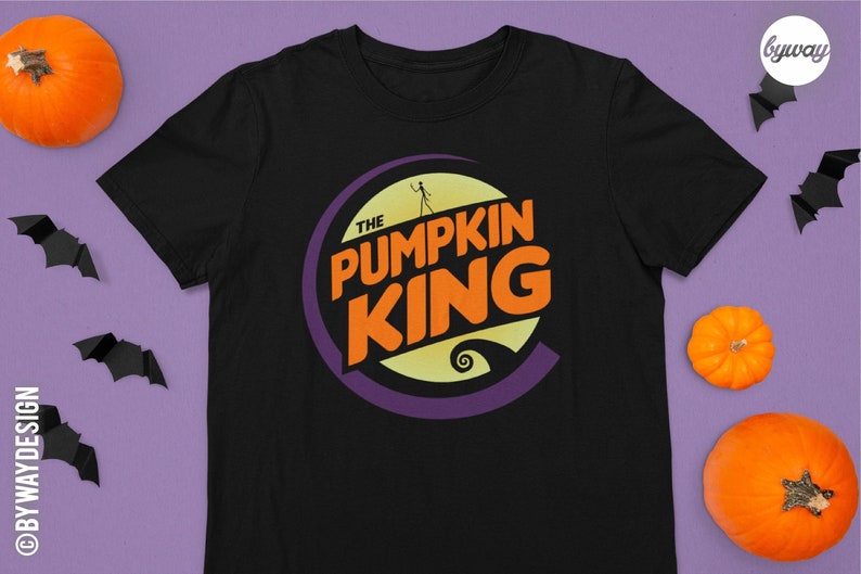 Puede incluir: Camiseta negra con un gr&aacute;fico circular morado, naranja y amarillo que dice "The Pumpkin King".