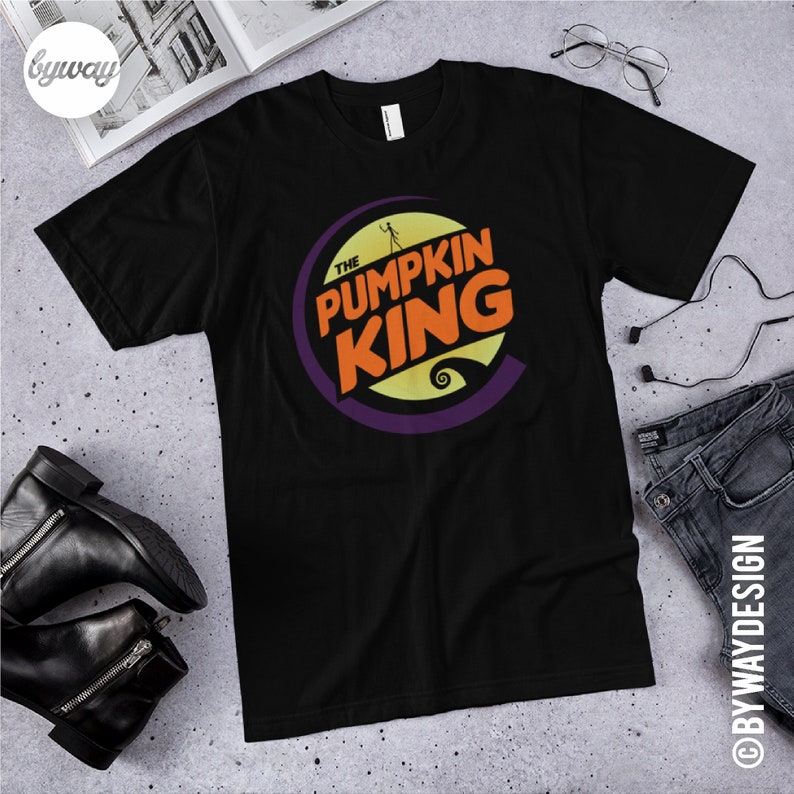 Puede incluir: Camiseta negra con un gr&aacute;fico de un c&iacute;rculo morado con el texto "The Pumpkin King" en letras naranja y amarillas. El gr&aacute;fico tambi&eacute;n incluye una silueta de Jack Skellington de la pel&iacute;cula "Pesadilla antes de Navidad".