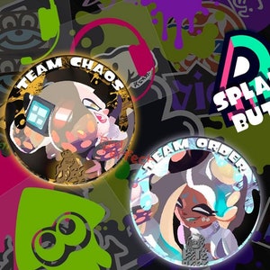 May include: A collection of Splatfest buttons featuring characters from the game. The buttons are round with colorful designs and text, including "Team Chaos," "Team Order," "Team Pearl," and "Team Marina."