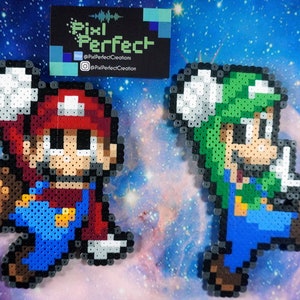 May include: Two pixel art figures of Mario and Luigi, made with perler beads. Mario is wearing his signature red and blue outfit, while Luigi is wearing his green and blue outfit. Both figures are in a running pose.