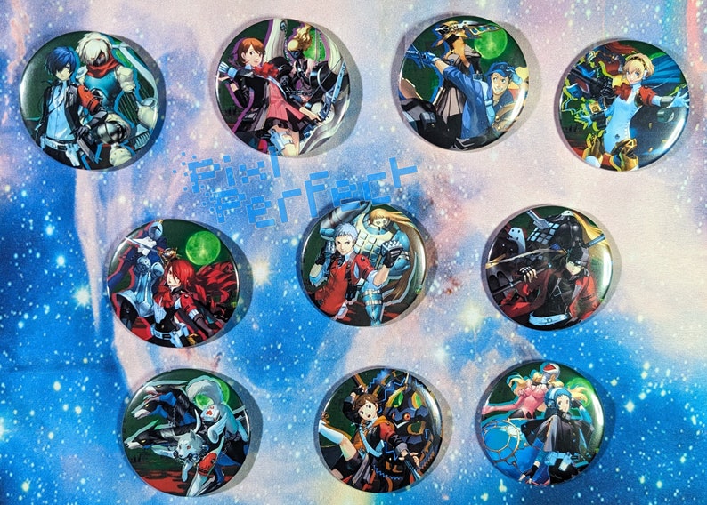 May include: Ten round, colourful buttons featuring anime characters from the Persona series. Each button has a different character and background.