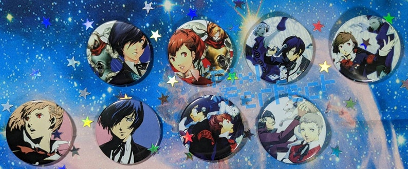 May include: A set of ten round, colourful anime character pins. The pins feature characters from the Persona series. The pins are all different sizes and shapes, and they are all set against a blue background with white stars.