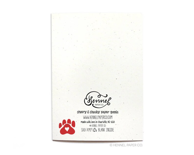 May include: A blank greeting card with a red paw print and a heart. The back of the card has the text "Sennel Paper Co. Cheery & Cheeky Paper Goods. www.hennelpaperco.com Made with love in Charlotte, NC-USA Sennel Paper Co. SKU:XM19 Blank Inside &copy; Hennel Paper Co."