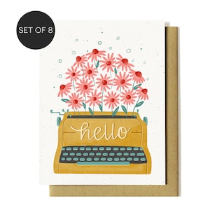 May include: Set of 8 greeting cards featuring a yellow typewriter with the word "hello" and a bouquet of pink flowers. The cards are on a white background with a kraft paper envelope.