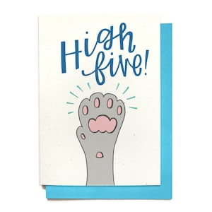 May include: A greeting card with a paw print giving a high five. The card is white with blue text that says "High five!" and a gray paw print with a pink pad.