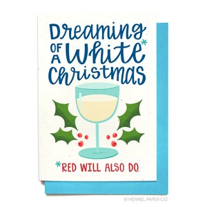 May include: A white Christmas card with a glass of white wine and holly leaves. The text reads "Dreaming of a White Christmas *Red will also do."