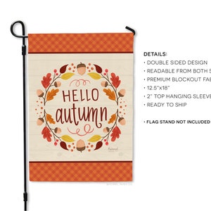 May include: A garden flag with the words "HELLO autumn" in a wreath of fall leaves and acorns. The flag is 12.5" x 18" and has a plaid border. It is designed to be readable from both sides and has a 2" top hanging sleeve.