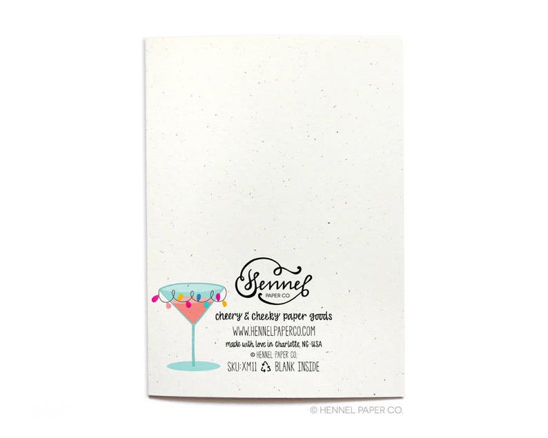 May include: Back of a blank greeting card with a light blue martini glass with colorful lights around the rim. The card is made by Sennel Paper Co. and has the text "cheery & cheeky paper goods" and "www.hennelpaperco.com".