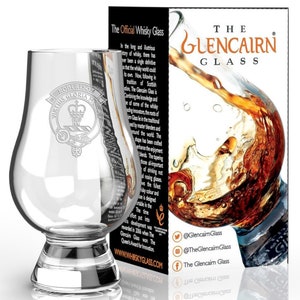 Może przedstawiać: Szklanka do whisky Glencairn wykonana z przezroczystego szkła, z szeroką podstawą i zaokrągloną czaszą. Szklanka jest grawerowana herbem Robertson Gloria Mors. Szklanka jest pokazana na białym tle, z pudełkiem z tyłu, na którym widnieje napis "The Glencairn Glass".