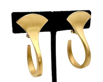 May include: A pair of gold hoop earrings with a unique fan-shaped design. The earrings are displayed on a black stand.