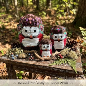 Peut inclure: Trois figurines de hiboux perlés de différentes tailles, aux couleurs marron, rouge et blanc. Les hiboux présentent des perles détaillées avec des motifs floraux et géométriques. Le texte "Beaded Perfectly Carol Webb" est en bas.