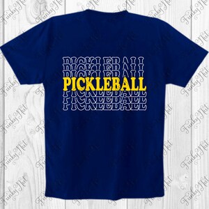 以下が含まれることがあります： ネイビーブルーのTシャツ。黄色で「PICKLEBALL」の文字がプリントされ、その下に白で繰り返される「PICKLEBALL」のデザイン。クルーネックのスタイルです。