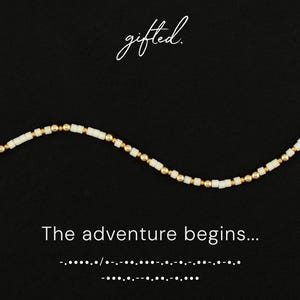 May include: A necklace with white square beads and gold-colored round beads on a black background. The word "gifted" is written in cursive at the top, and the phrase "The adventure begins..." is at the bottom.