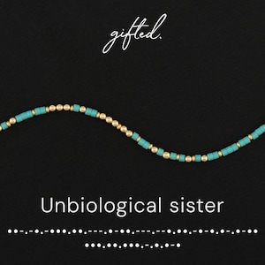 Könnte beinhalten: Ein Perlenarmband mit abwechselnden türkisfarbenen zylindrischen Perlen und kleinen goldenen kugelförmigen Perlen. Der Text "gifted." steht oben und der Text "Unbiological sister" ist über einer Zeile aus Morsezeichen-Punkten und Strichen zentriert.