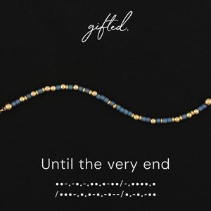 Könnte beinhalten: Ein Perlenarmband mit abwechselnden matten schieferblauen zylindrischen Perlen und metallisch goldenen kugelförmigen Perlen. Der Text gifted. steht über dem Armband, während der Text Until the very end und Morsezeichen darunter gedruckt sind.