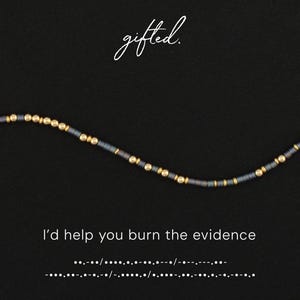 May include: A beaded bracelet featuring alternating matte dark gray cylindrical beads and small metallic gold spherical beads. The text gifted. appears above the bracelet, and the text I'd help you burn the evidence with Morse code below.