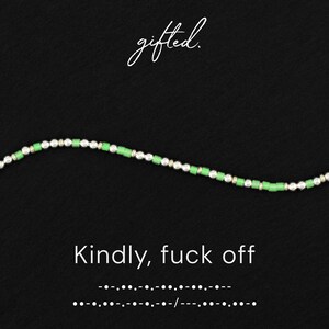 May include: A beaded bracelet featuring alternating bright green cylindrical beads and textured silver-toned spherical beads. The text "gifted." appears at the top, with "Kindly, fuck off" and a line of Morse code printed below the bracelet.