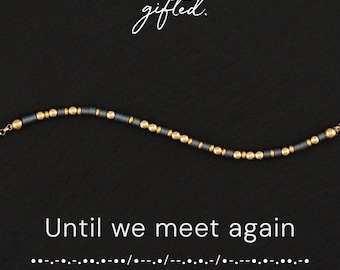 May include: A beaded bracelet featuring alternating dark grey cylindrical beads and small gold spherical beads. The text gifted. appears above the bracelet, while the text Until we meet again and Morse code dots and dashes appear below.