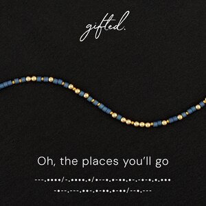 Könnte beinhalten: Ein Perlenarmband mit abwechselnden matten schieferblauen zylindrischen Perlen und kleinen metallisch goldenen kugelförmigen Perlen. Der Text "gifted." steht oben, und "Oh, the places you'll go" mit Morsecode ist unten aufgedruckt.