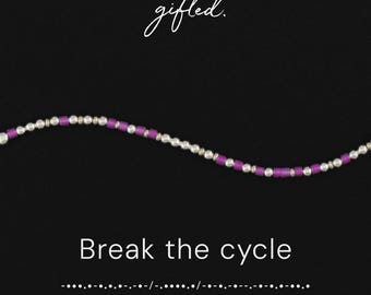 May include: A beaded necklace featuring alternating metallic silver-toned spheres and cylindrical purple beads. The image includes the text gifted. at the top, the phrase Break the cycle in the center, and a line of Morse code at the bottom.