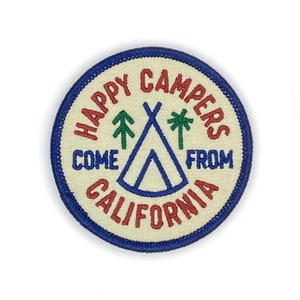 May include: A white circular patch with blue stitching around the edge. The patch has a red and white embroidered design that says "Happy Campers Come From California" with a blue tent and green trees and palm trees in the center.