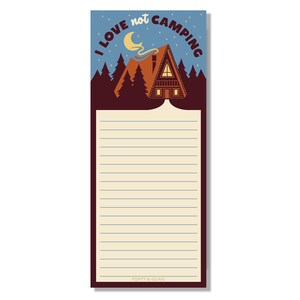 May include: A notepad with the text "I love not camping" above a cabin illustration. The notepad has a lined section for notes and the words "Poppy & Quail" at the bottom. The background is blue with a crescent moon and stars.