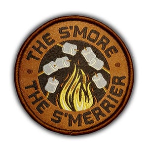 May include: Embroidered patch with a brown border and background. The patch features the text "THE S'MORE THE S'MERRIER" in brown, surrounding a central image of a campfire with marshmallows on sticks. The marshmallows are white, and the flames are yellow and orange.