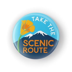 May include: A blue and navy blue button with the text "Take the Scenic Route" in white and orange lettering. A yellow California poppy flower with a green stem is in the upper left corner of the button.