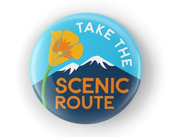 Puede incluir: Un botón azul y azul marino con el texto "Take the Scenic Route" en letras blancas y naranjas. Una flor de amapola de California amarilla con un tallo verde se encuentra en la esquina superior izquierda del botón.