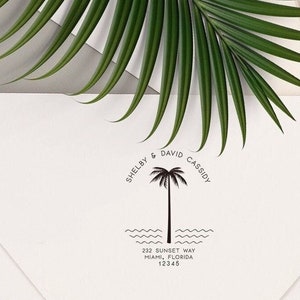 May include: A black and white return address stamp with a palm tree design. The text reads "Shelby & David Cassidy" and "232 Sunset Way, Miami, Florida 12345".