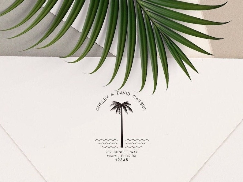 May include: A black and white return address stamp with a palm tree design. The text reads "Shelby & David Cassidy" and "232 Sunset Way, Miami, Florida 12345".