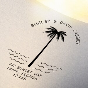 May include: Black and white illustration of a palm tree with the text "Shelby & David Cassidy" and "232 Sunset Way, Miami, Florida 12345" below the tree.