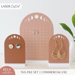 May include: Three wooden earring display stands with a moon and crescent moon design. The stands are in shades of brown and pink. The stands are laser tested and are for commercial use. SVG file set.